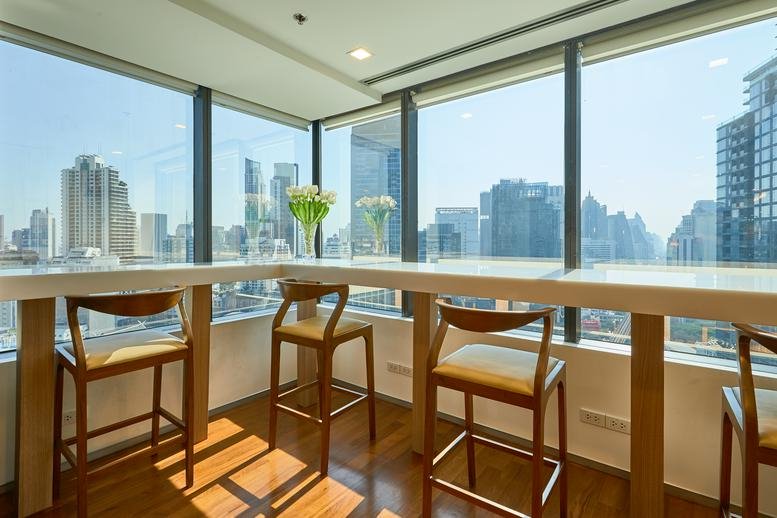 High-top wooden window counter with bar stools and city views at Two Pacific Place Building.