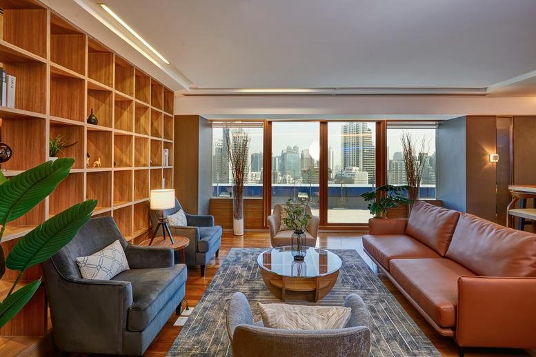 Spacious lounge at Two Pacific Place Building with leather sofas and floor-to-ceiling windows.