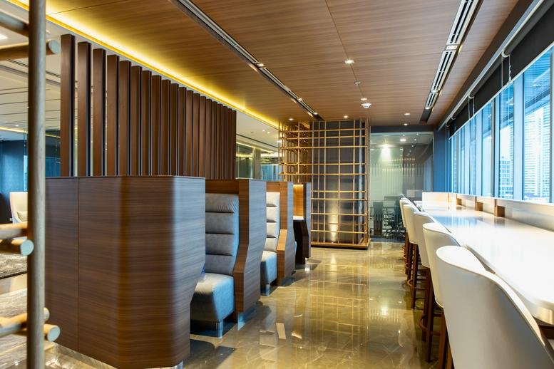 Spacious coworking area at UBC II Building with private wood-paneled booths and window-side seating.