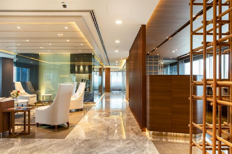 Polished reception and lobby area at the UBC II Building featuring warm wood paneling and marble floors.