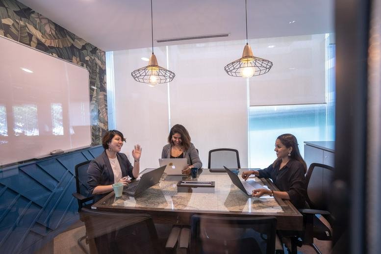 Professional meeting room at The Podium Tower 3 UOA Business Park with three women around a table.
