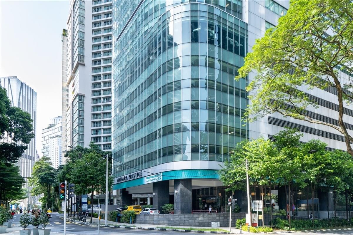 Exterior view of the curved glass facade of Menara Prestige in Kuala Lumpur.
