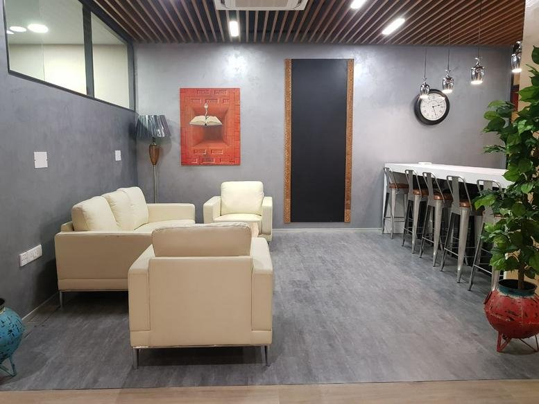 Lounge area with cream sofas, red artwork, and a breakfast bar at Tower 15, Cybercity, Magarpatta City.