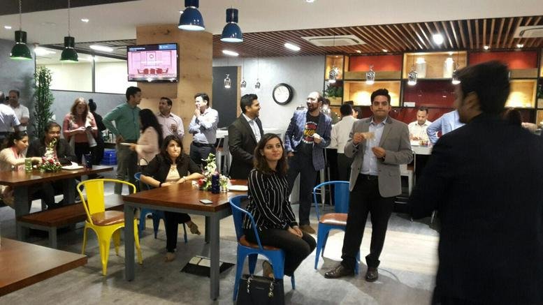 Vibrant breakout area at Cybercity, Magarpatta City with people socializing near a cafe bar.