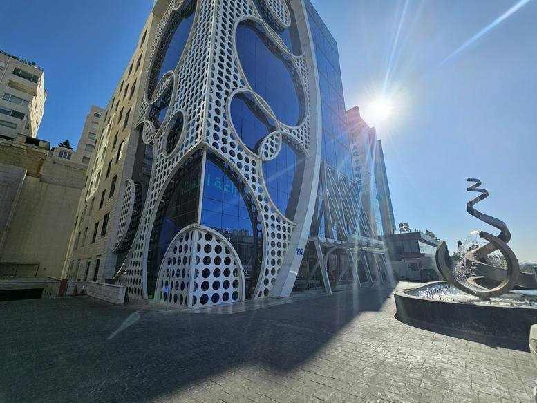 Modern architectural exterior of the V Business Center with a patterned white facade and blue glass.