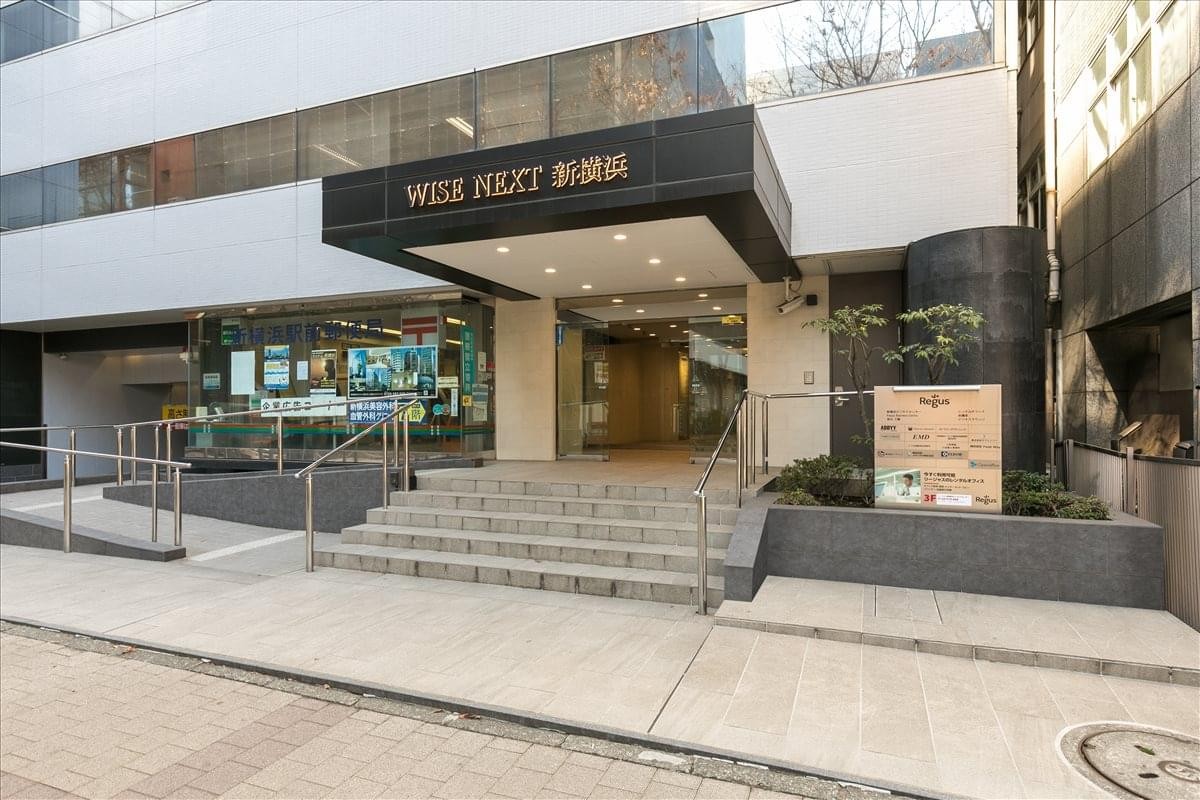 Exterior entrance of Wise Next ShinYokohama featuring a dark granite facade and wide steps.