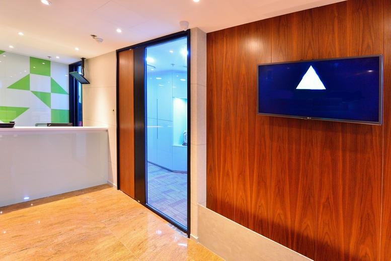 Reception area at Woon Lee Commercial Building with wood paneling and a modern white desk.