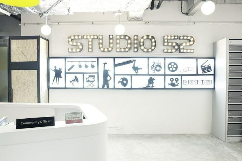 Bright reception area at The Galaxy with a branded feature wall and white curved front desk.