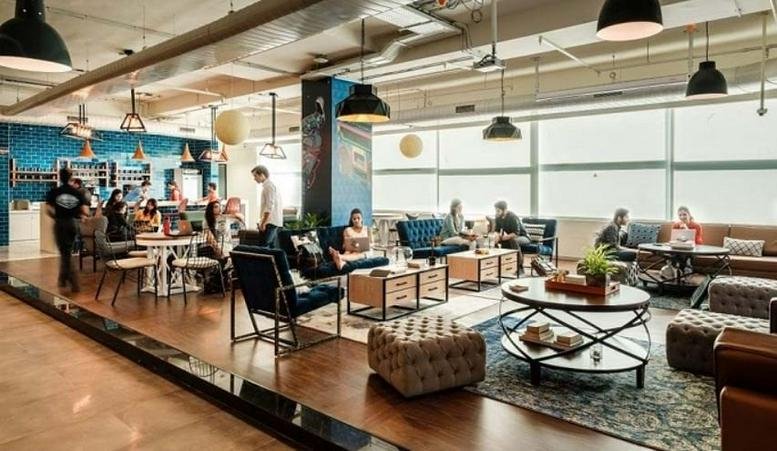 Spacious lounge with diverse seating and large windows.