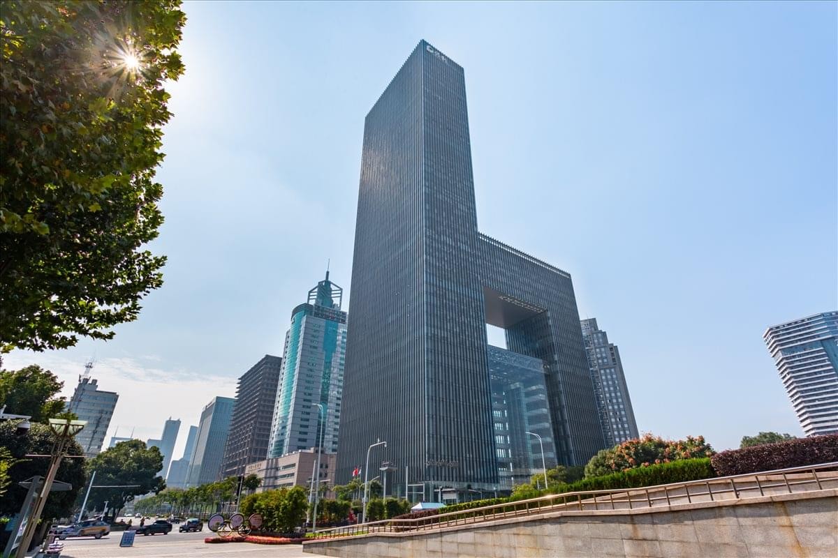 Exterior view of the tall glass facade of Wuhan Poly Plaza with a distinctive cutout design.