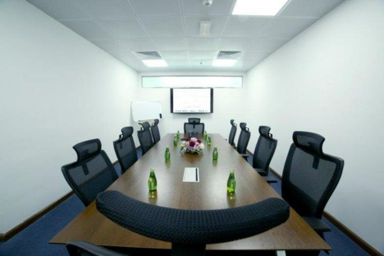 Spacious boardroom at XL Tower with a long wooden table and modern mesh chairs.