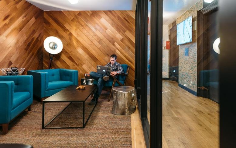Spacious lounge at Yeoksam Station, 142 Teheran-ro with wood-paneled walls and teal armchairs.
