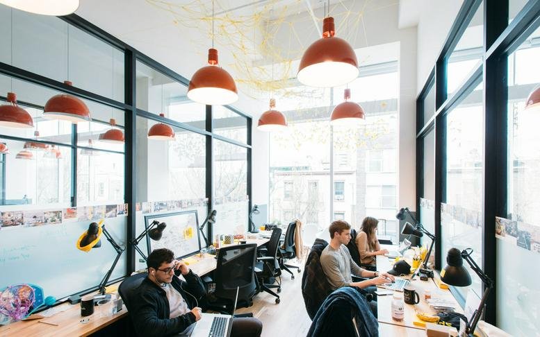 Bright, sunlit open-plan workspace at Yeoksam Station, 142 Teheran-ro, Seoul with orange pendant lights.