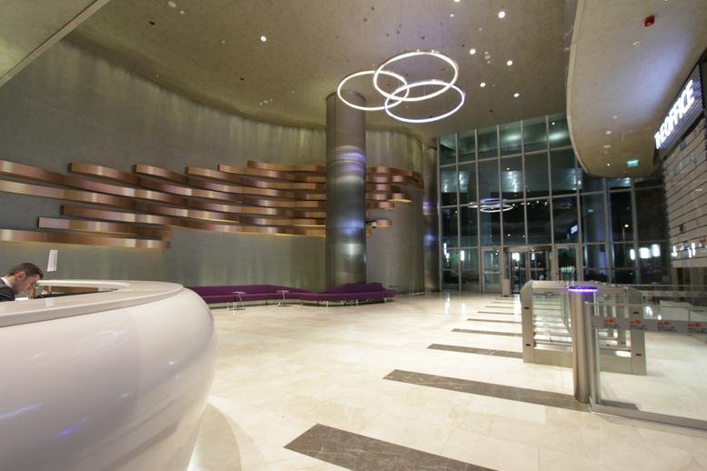 Spacious reception lobby at Mall of İstanbul with a curved desk and modern ring light fixtures.