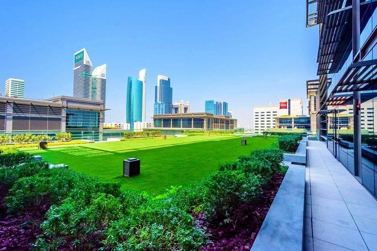 Rooftop terrace with green lawn and skyline views at the Dubai World Trade Center.