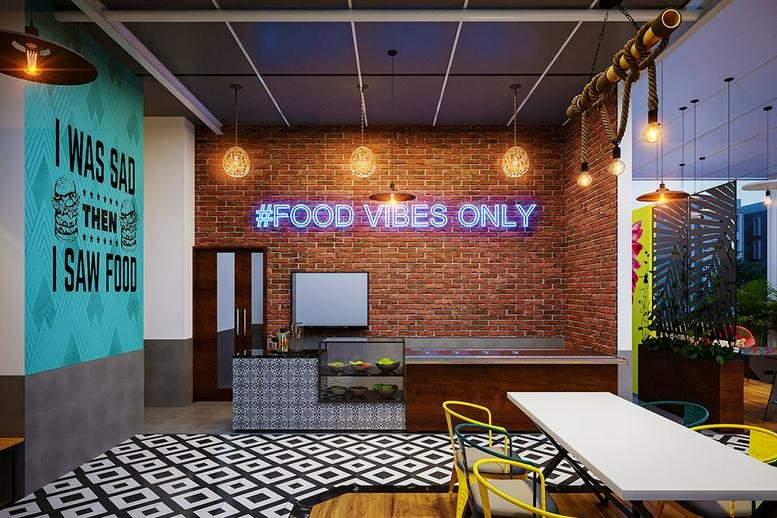 Spacious communal cafe area at Park, HAL Old Airport Road with neon signage and brick feature wall.