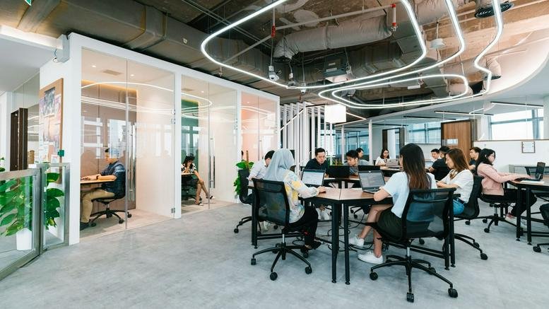 Modern open-plan office at Naza Tower, Platinum Park with sleek white glass partitions and geometric ceiling lights.
