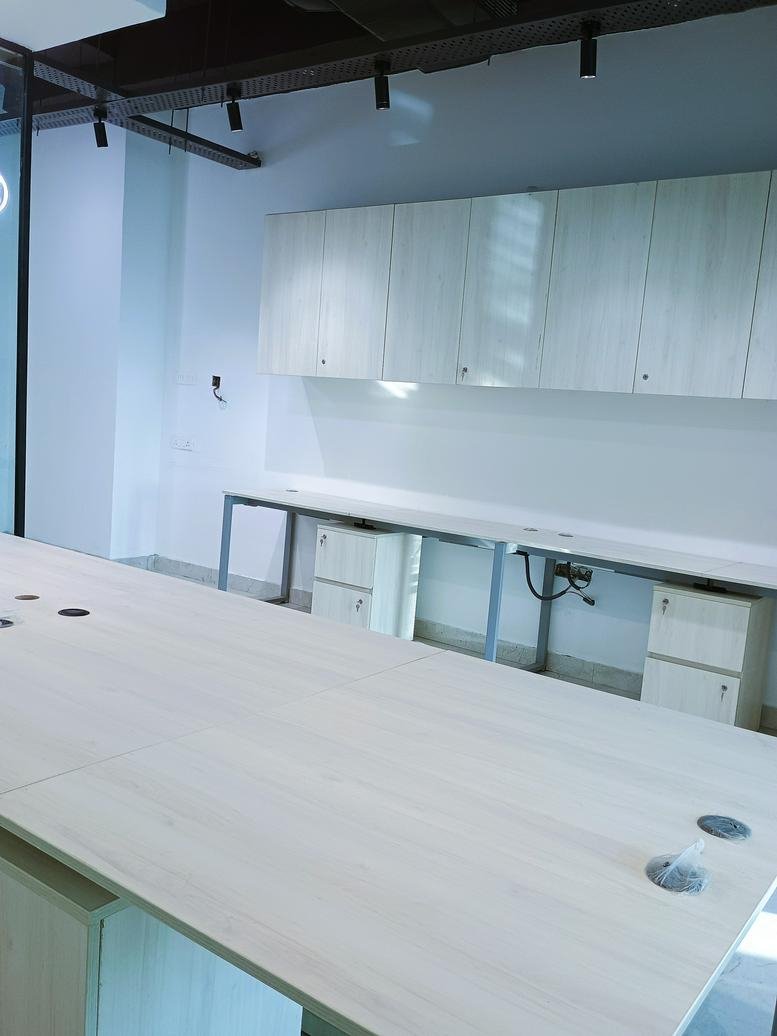 A professional workspace featuring built-in white cabinetry and a long integrated desk at Sector-132, Noida.