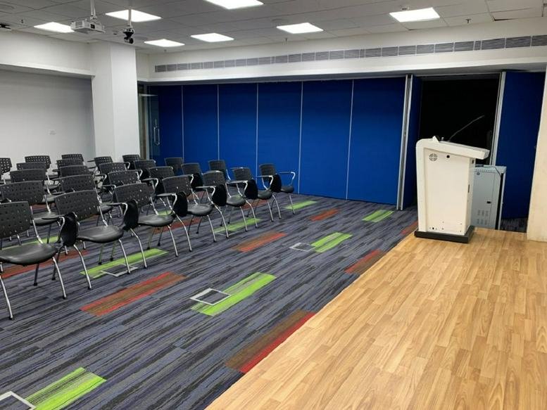 Meeting room at Plot No-17, Sector-18, Phase 4, Udyog Vihar, Gurugram with tiered seating and a white lectern.