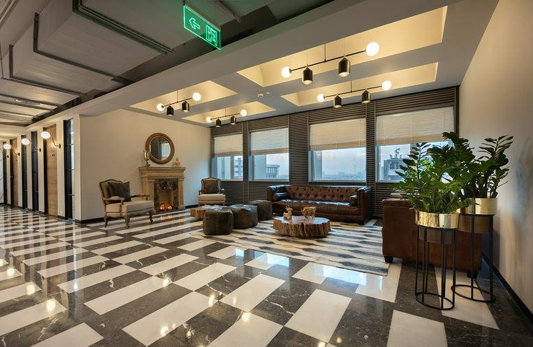 Spacious reception lounge with comfortable sofas and large windows.
