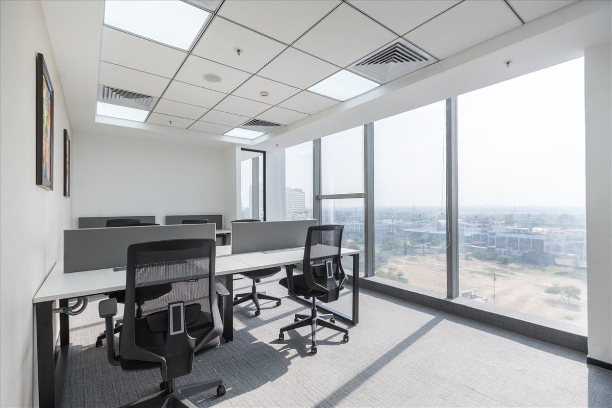 Bright open-plan office with desks and floor-to-ceiling city views at Plot No. 4 B, District Centre.
