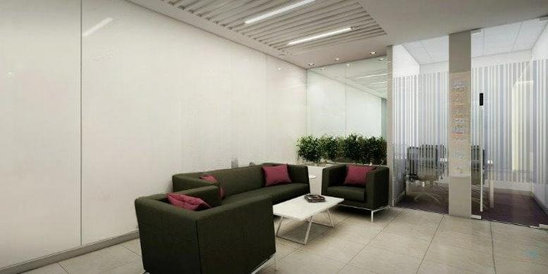 Spacious reception lounge at Pride House with modern dark sofas and a white coffee table.