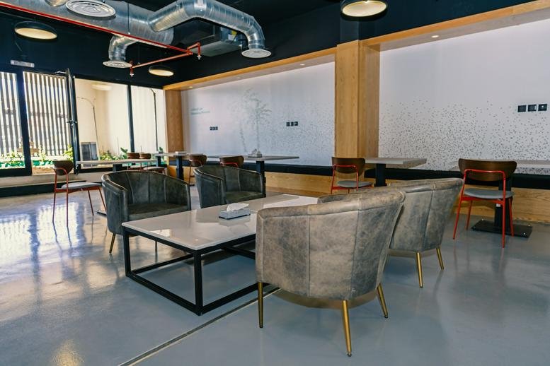 Spacious communal lounge at Prince Turki Ibn Abdulaziz Al Awwal Rd, An Nakheel with plush grey armchairs.
