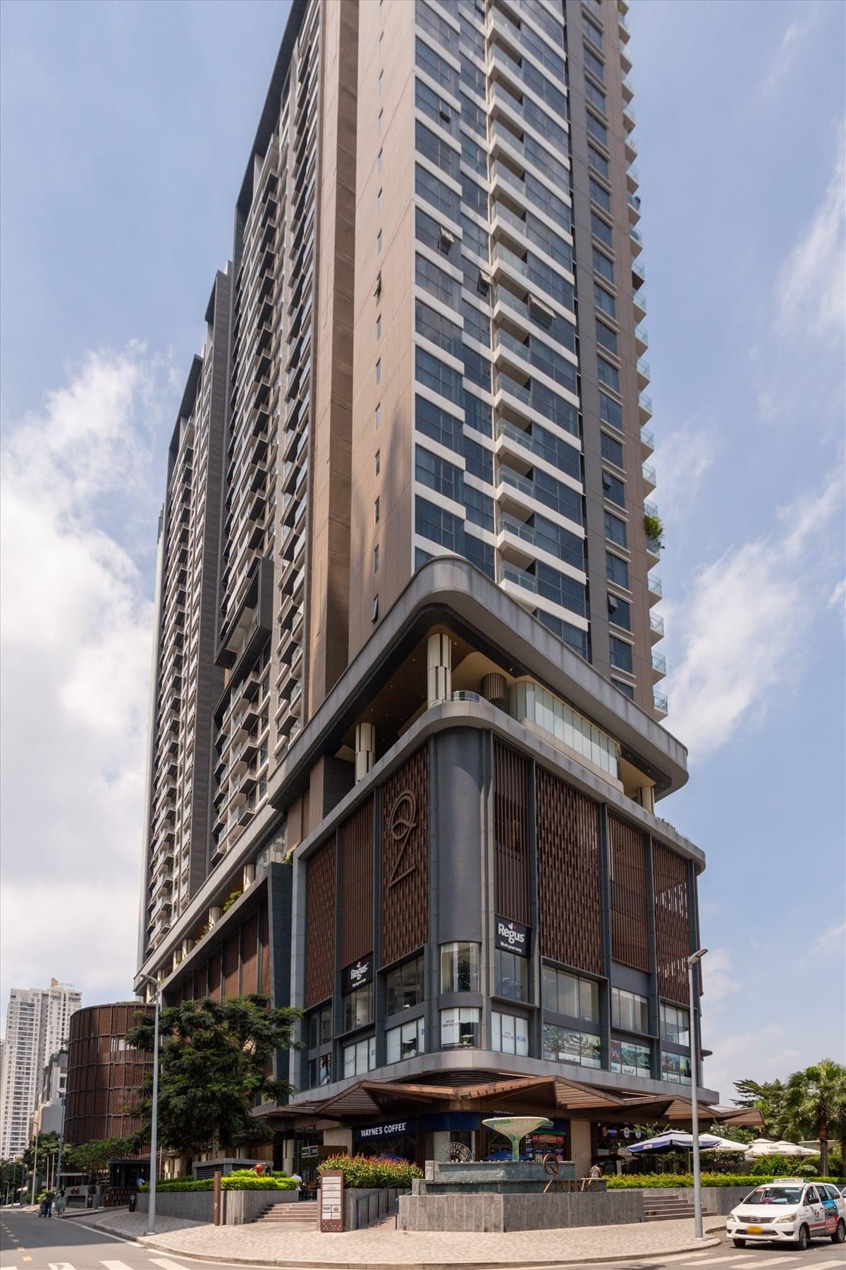 Tall exterior view of the modern Q2 Thao Dien Residence with a tiered facade.