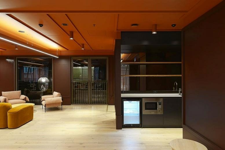 Modern communal breakout space at Queen & Collins, Level 1 featuring a kitchenette and lounge seating.