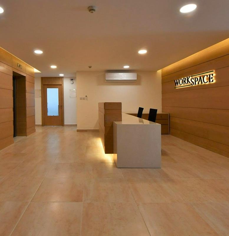 Spacious reception area with a minimalist white desk at مجمع زينة التجاري.