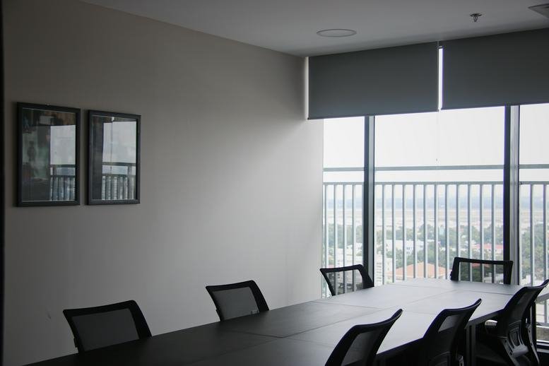 Spacious boardroom at Republic Plaza featuring dark table and city views through large windows.