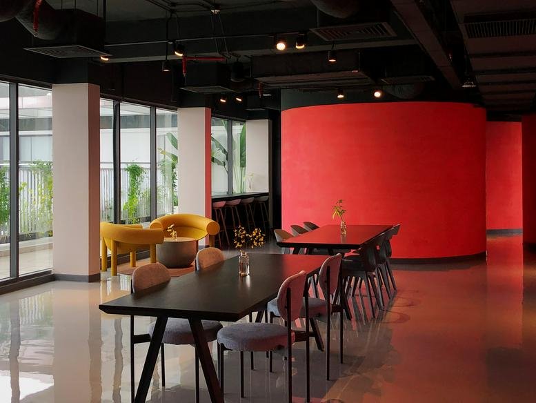Spacious interior at Republic Plaza with warm lighting, dark wooden tables, and a curved red accent wall.