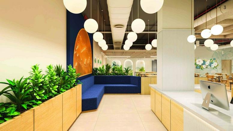 Bright reception area at RMZ Centennial, C-Block, 5th Floor featuring blue seating and globe pendant lights.