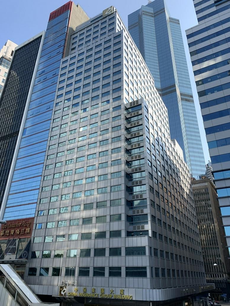Exterior view of the silver-toned China Insurance Group Bldg under a clear sky.