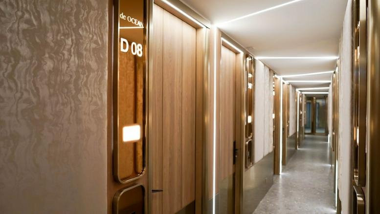 Modern wooden hallway at Mai Tak Industrial Building featuring sleek integrated lighting and gold accents.