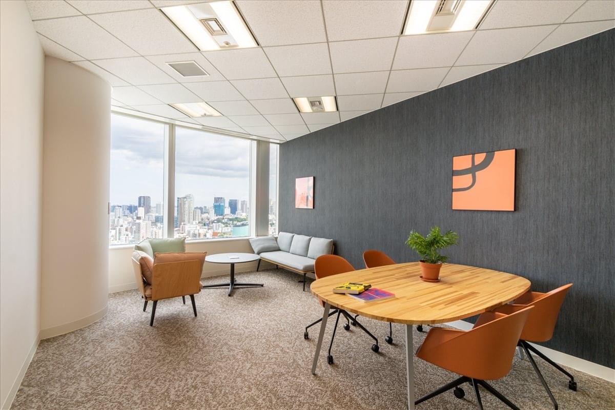 Contemporary office suite at Roppongi Hills Mori Tower 11F featuring a round wood table and slate grey accent wall.