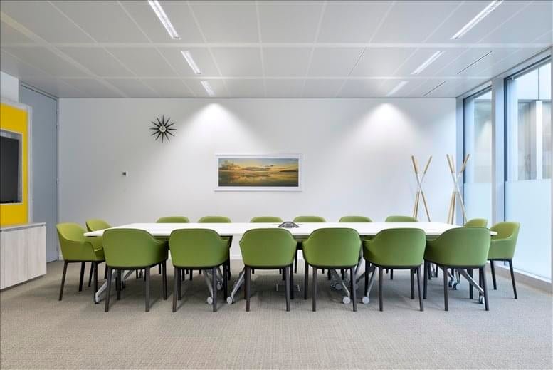 Large meeting room with green chairs around a long table.