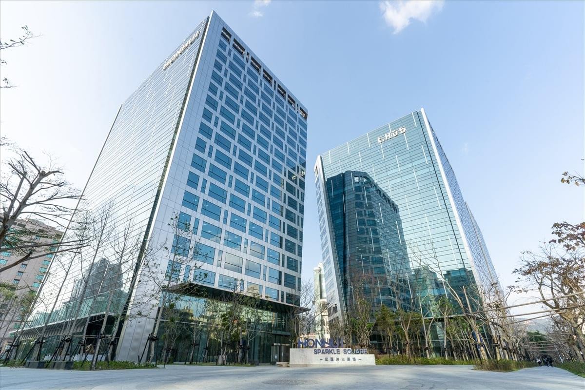 Exterior view of the glass-facade Hongwell Neihu Center under a clear blue sky.