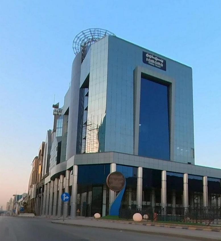 Exterior view of the glass-facade Samama Holdings building with its unique rooftop structure.