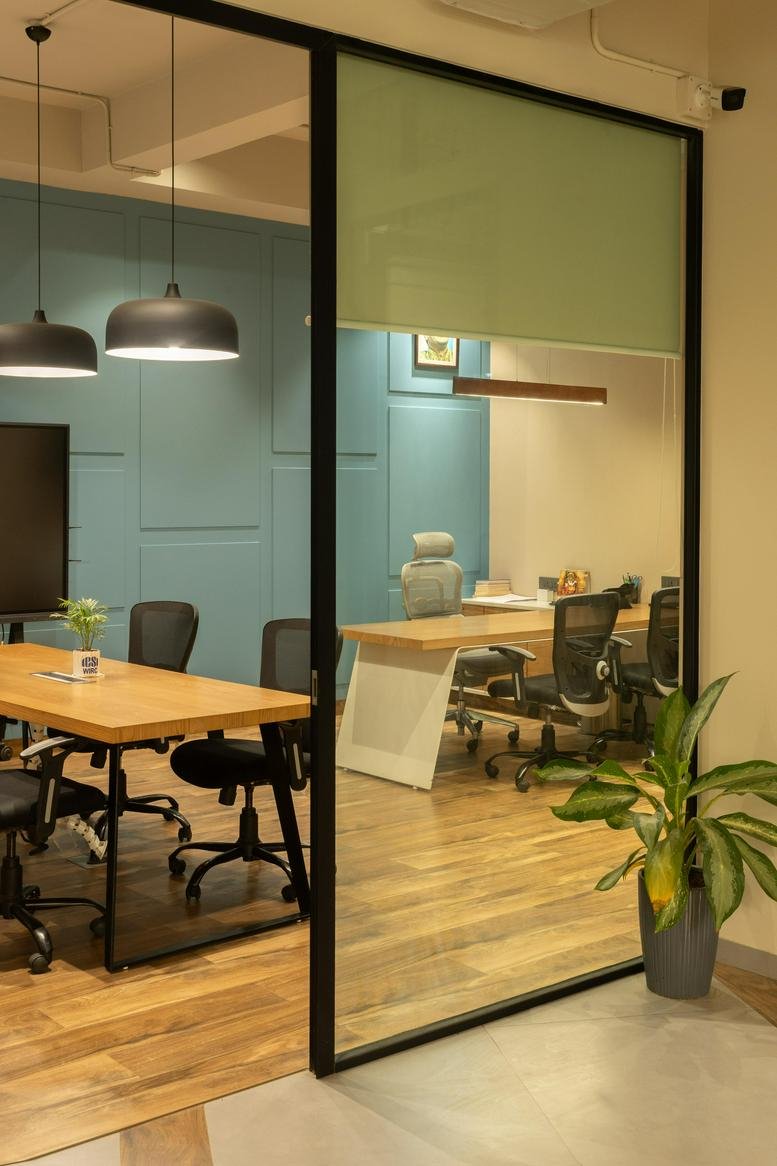 Spacious meeting room at Brady Glady’s Plaza featuring wooden tables and blue paneled walls.