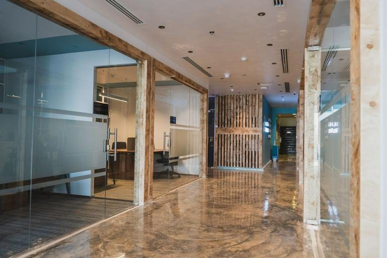 Spacious hallway with polished floors and glass-walled suites at Sharik Café, Prince Turkey Street.