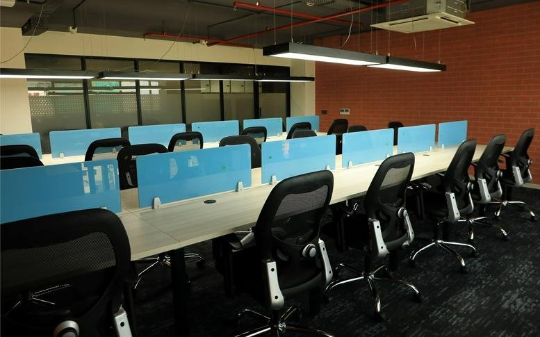 Open-plan workspace with rows of desks featuring blue privacy screens at 3rd Floor, Shilp Zaveri.