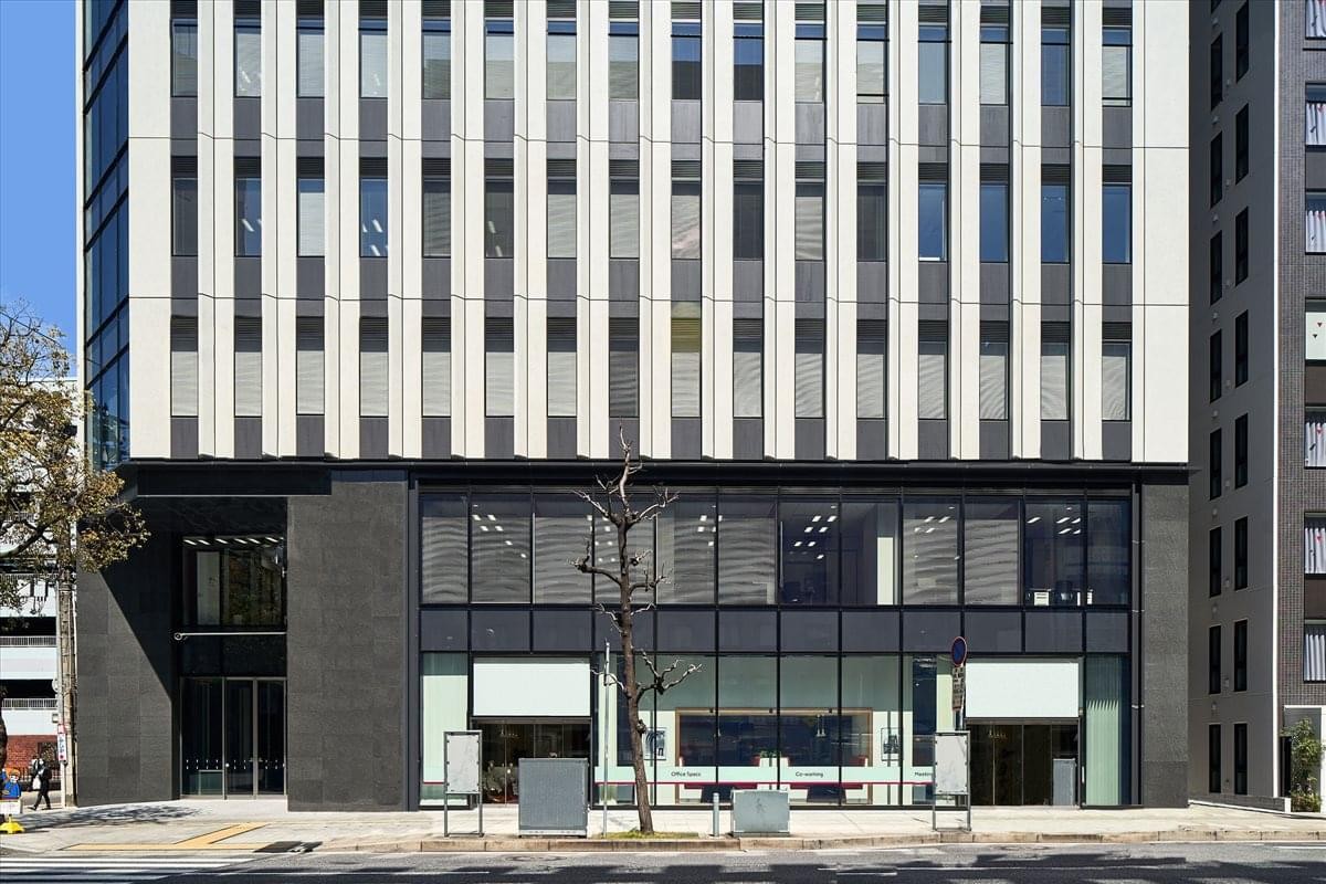 Exterior view of the modern glass and stone facade of the Shin Hiroshima Building 1F & 2F.