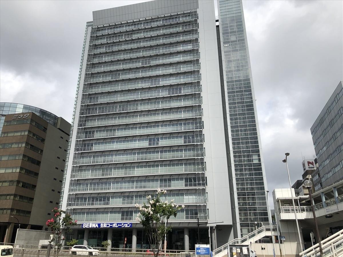 Exterior view of the modern high-rise Shin Yokohama Square building under a bright sky.