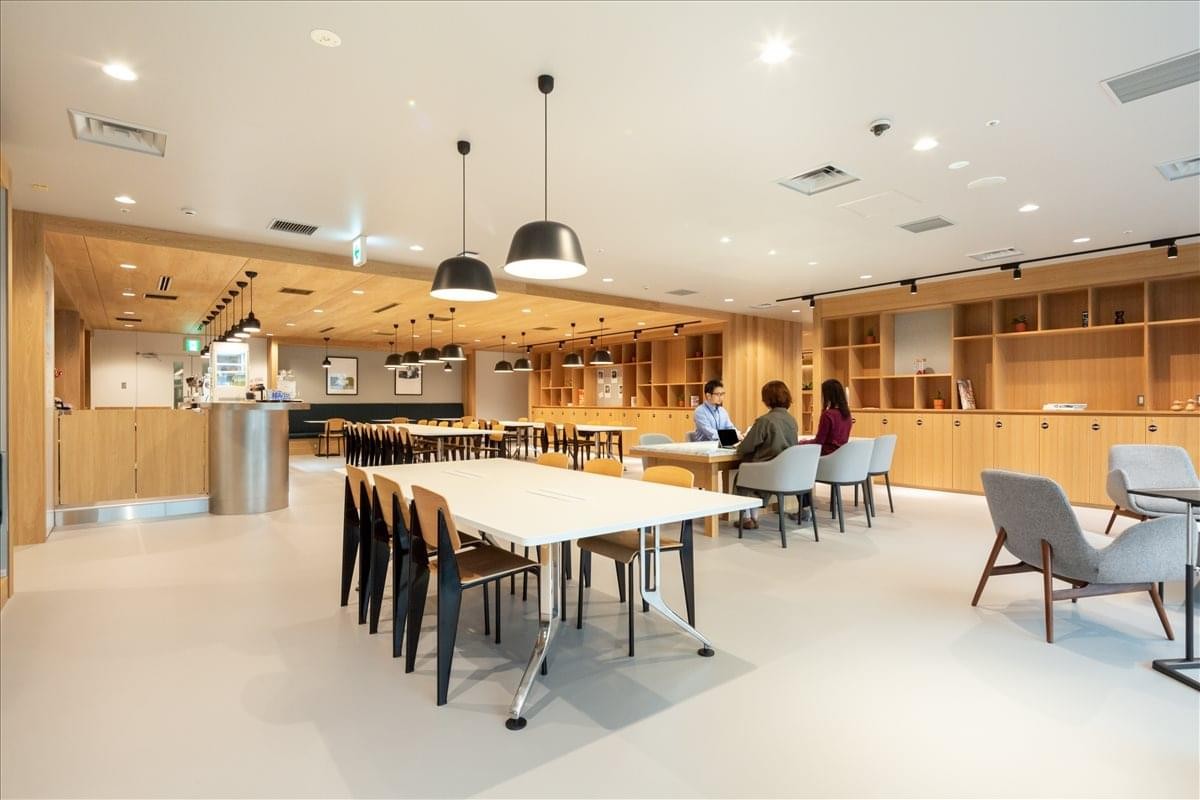 Spacious communal lounge with wooden accents and modern pendant lighting.