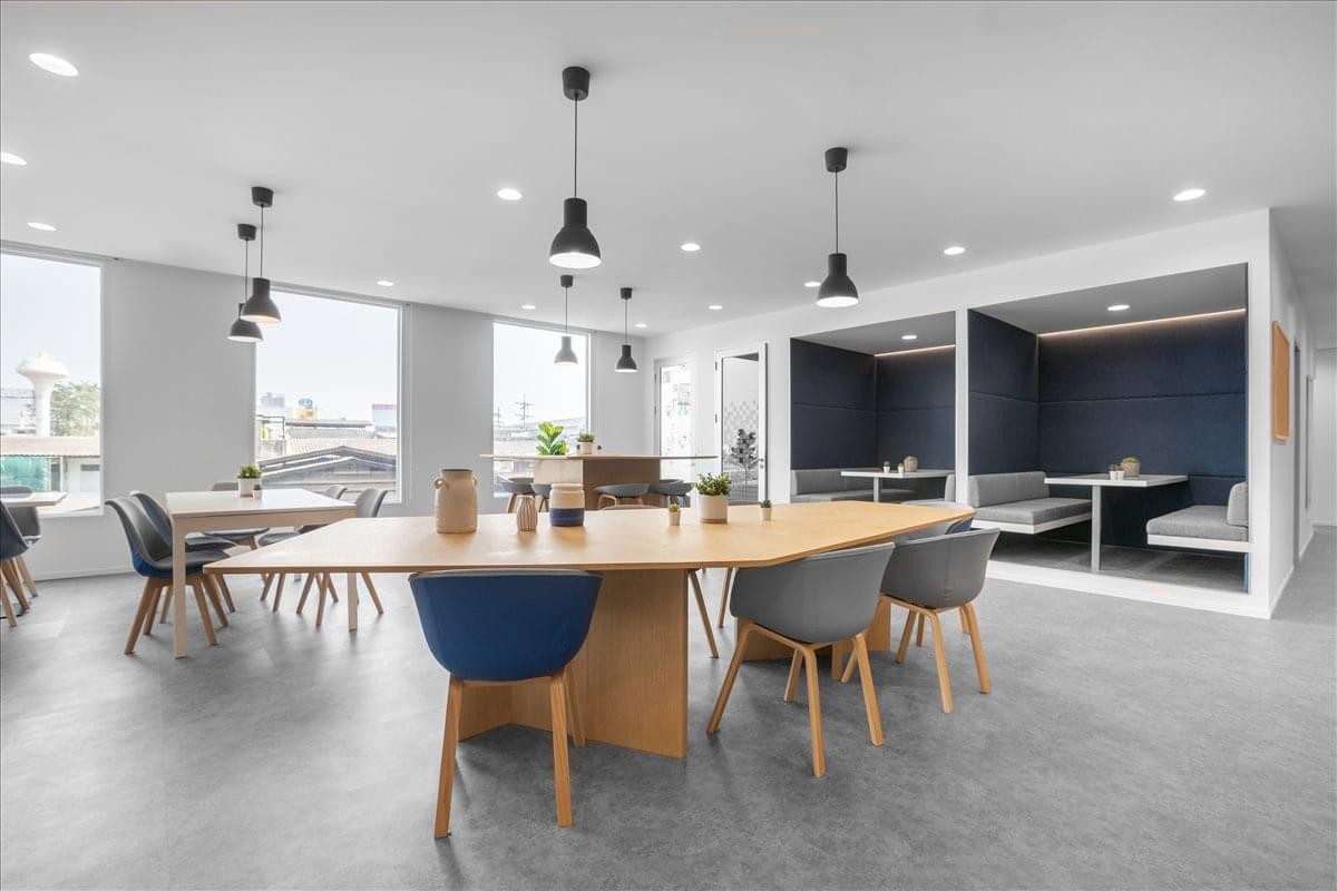 Modern breakout lounge featuring various seating options and black pendant lighting.