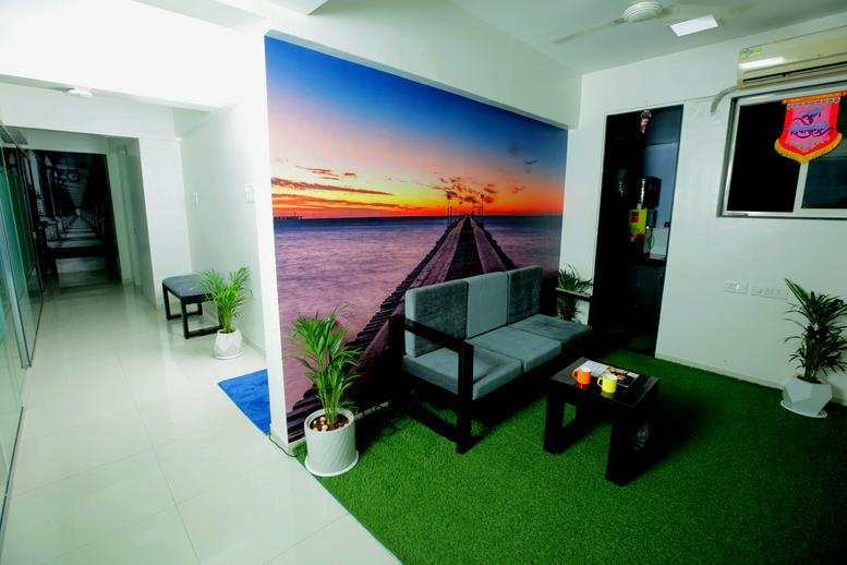 Vibrant waiting area with artificial grass and a scenic sunset mural.