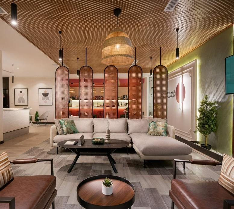 Spacious interior common area of the Smou Tower with a wide sofa, wooden ceiling, and stylish partition.