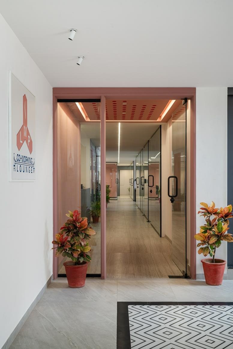 Entrance of the office at 3rd floor B wing, Sun Enclave, karelibaug with pink frames and plants.