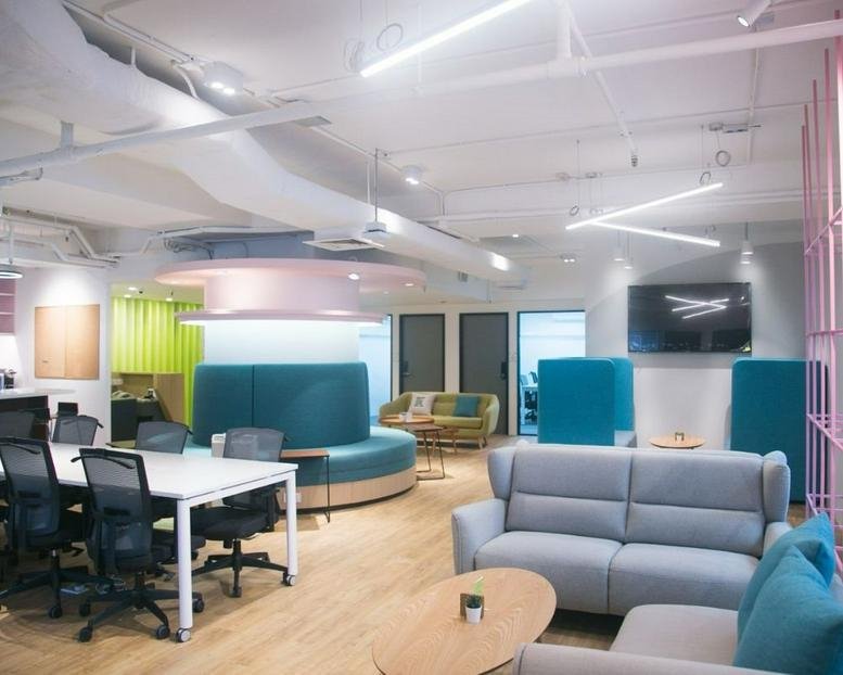 Spacious communal lounge at Sunbeam Centre with teal booths, sofas, and modern lighting.